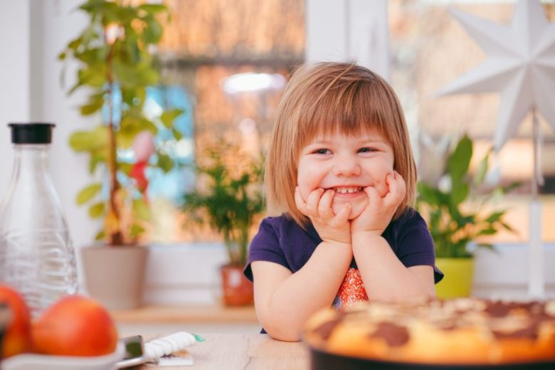 child with hands on face